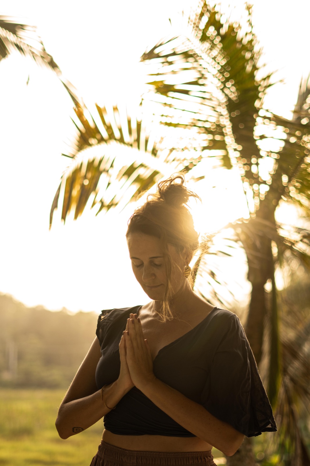 Namaste im Abendlicht unter Palmen