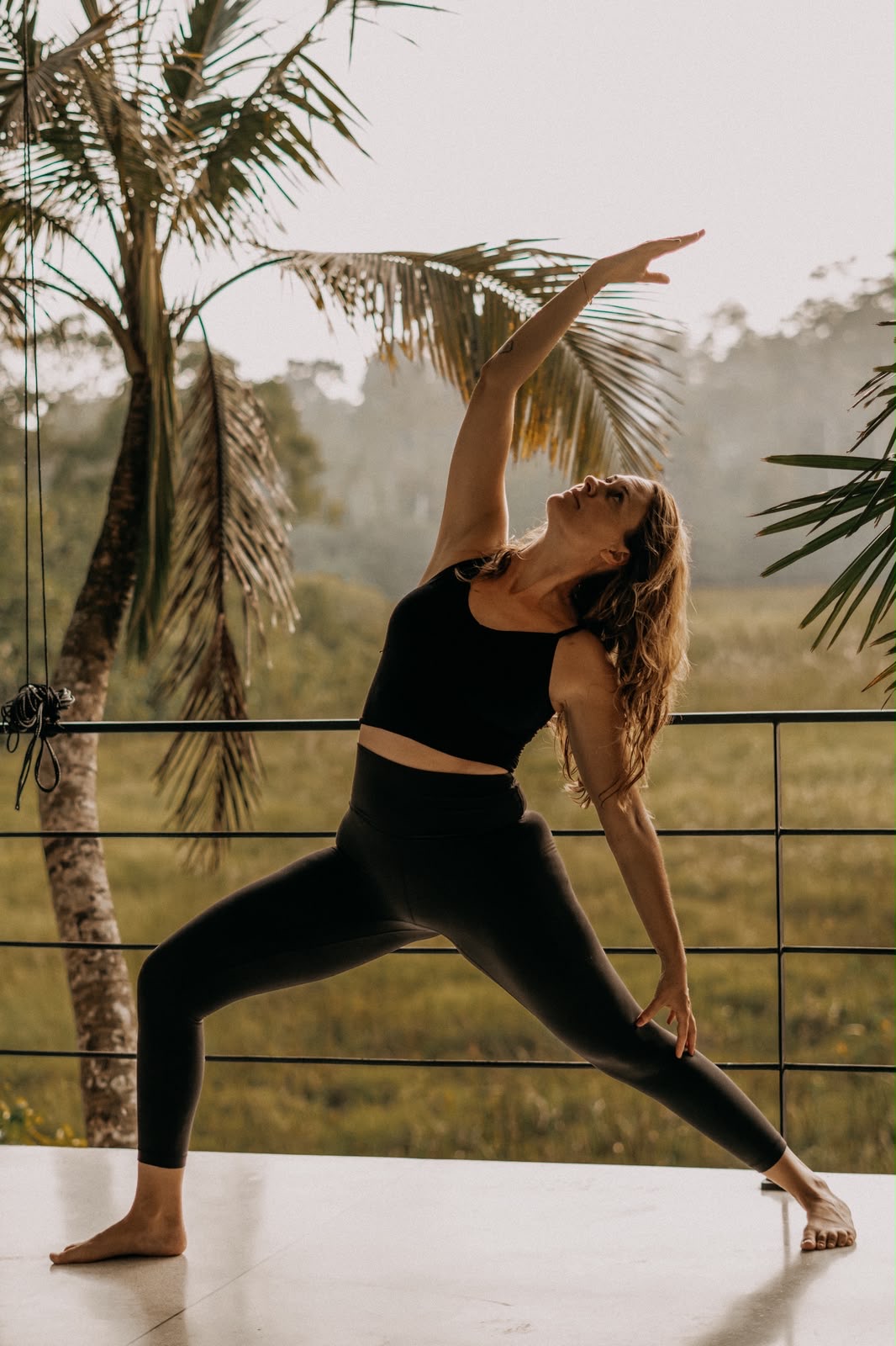 Yoga auf der Terrasse zwischen Palmen